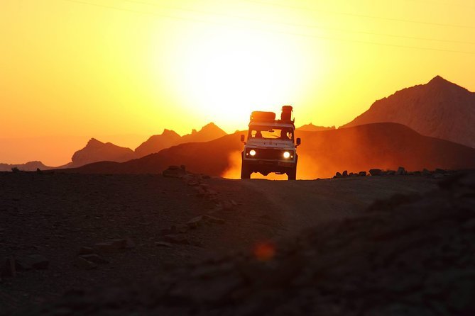 A jeep crossing the desert as the sun rises