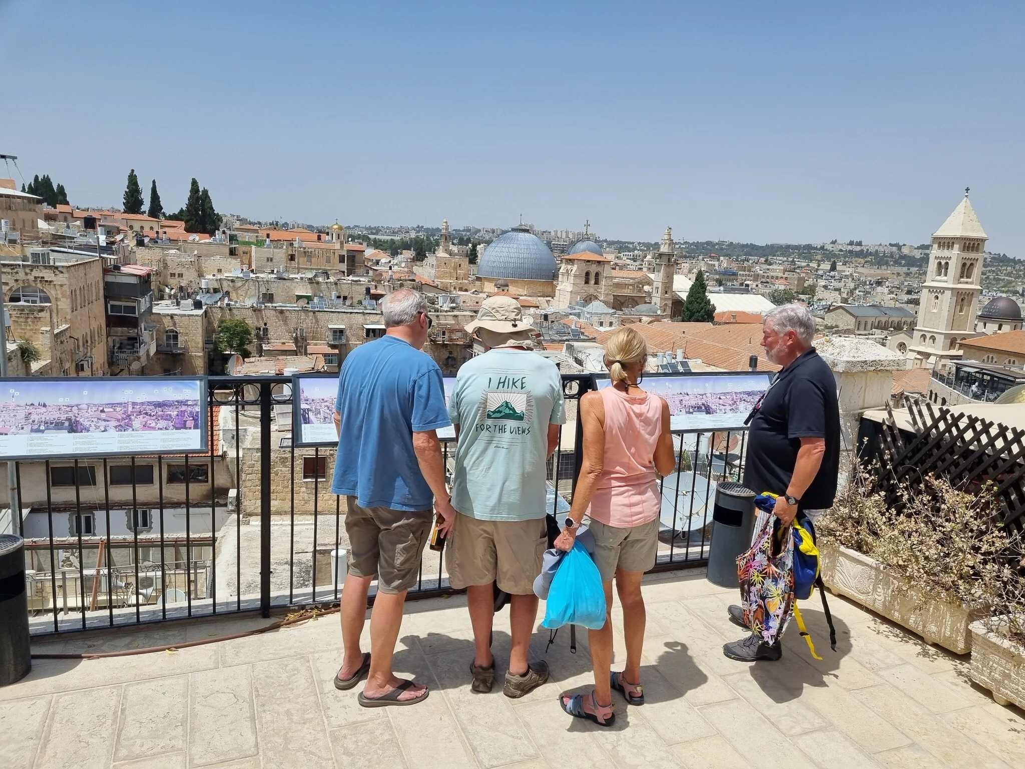 Travelers reading the Old City skyline from a rooftop terrace